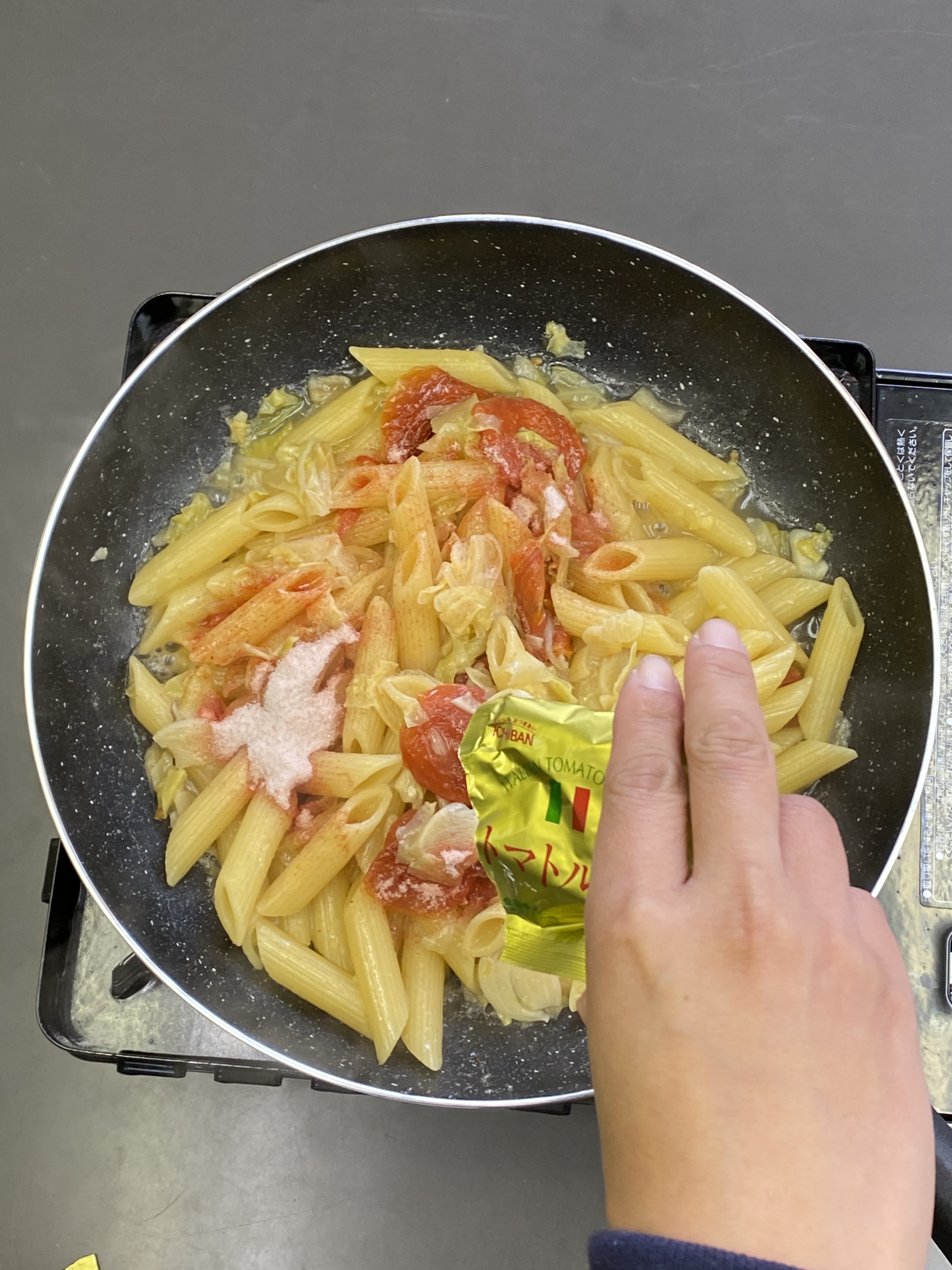 ペンネが硬ければ水を足し、更に煮込みます。良い硬さになったら、トマトソースを入れて混ぜ合わせます。