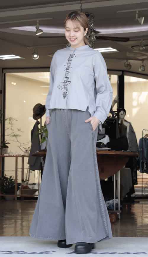 タテにロゴプリントのバックロングシャツとフレアーパンツ