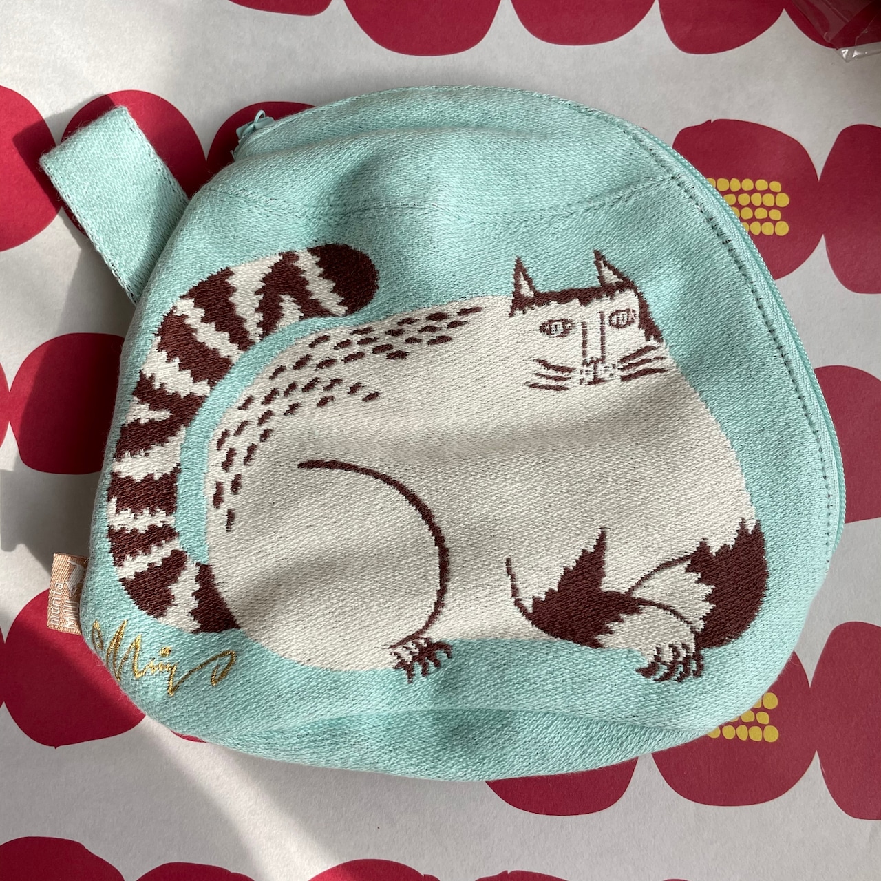 荷物を入れると自立する森田MiWさんのまち付きポーチ「公園の大きな樹のネコたち」。