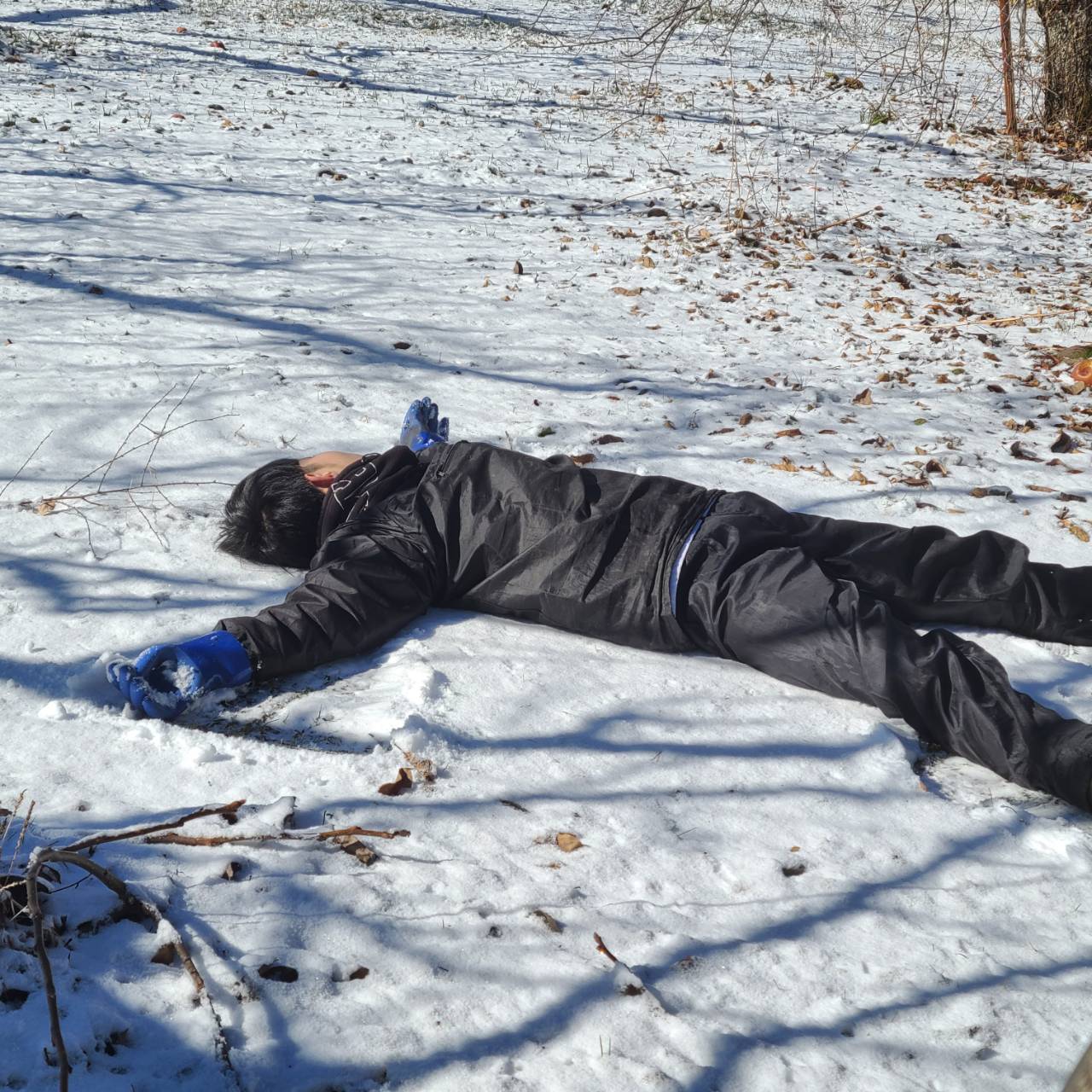【雪の上に寝転がる中学生】
