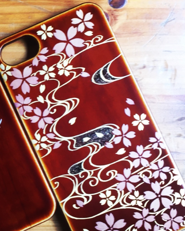 飛騨春慶の漆塗りiPhoneケースです。オーダーメイドで桜吹雪の蒔絵を施しました。