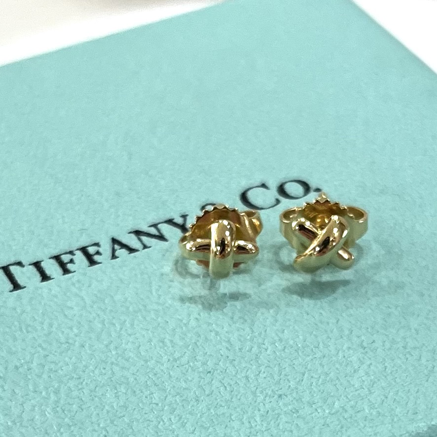 耳元でさりげなく輝く、Tiffany & Co.のクロスモチーフピアス。
